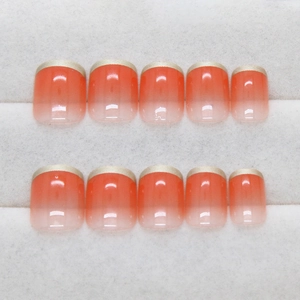 French short square press-on nails with orange gradient and gold metallic edges