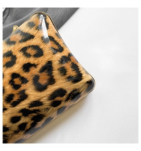 Close-up of gloss leopard print evening bag texture with polished fashion finish