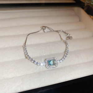 Detailed close-up of a vintage silver flower bracelet with blue emerald-cut gemstone