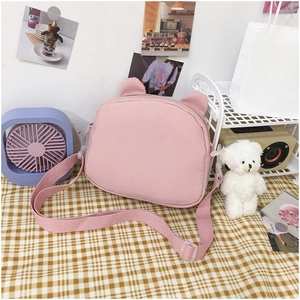 Detailed view of pink canvas crossbody bag with cute bear ears and adjustable strap