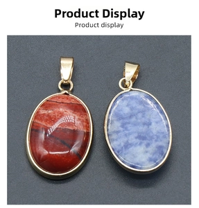 Detail of oval natural stone pendants in red and blue with gold plated metal edges