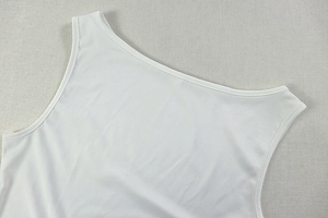 Close-up of a white sleeveless dress featuring a round neckline and fine knit texture