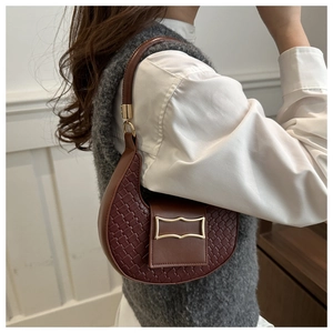 Dettaglio borsa marrone scuro con trama intrecciata e fibbia vintage dorata