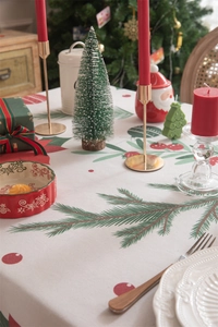 Detailed view of Christmas tablecloth featuring festive pine branch and berry patterns