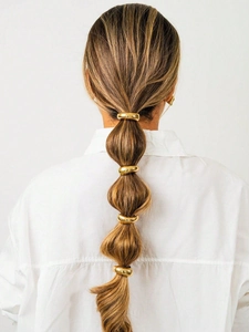 Close-up of golden metal bubble braid ring hair clips set on a stylish ponytail hairstyle