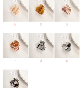 Detailed grid view of small marble acrylic hair claws in multiple colors and patterns