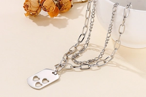 Close-up of double-layered stainless steel necklace with hollowed-out heart rectangular pendant