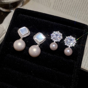 Macro view of zircon flower pearl earrings on black velvet in a jewelry box
