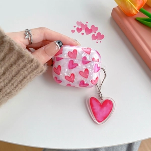 Detailed view of marble heart pattern AirPods case with a matching charm pendant