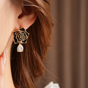 Gros plan de boucles d'oreilles rose noire vintage avec bords dorés et zircons gouttes