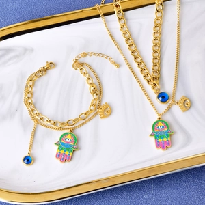 Golden Hamsa Hand and Evil Eye jewelry set on marble tray with necklaces and bracelets