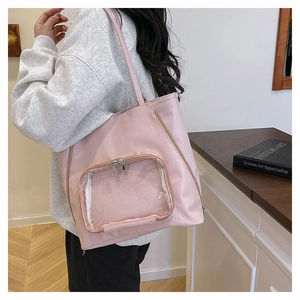 Vista laterale di borsa tote rosa con tasca trasparente indossata da modella in ambiente luminoso