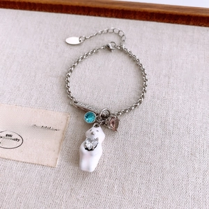 Detailed shot of silver bear bracelet with colorful crystals on a textured linen fabric