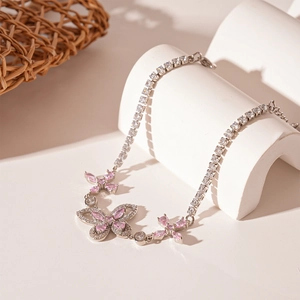 Close-up of butterfly bracelet with pink and clear zircons on cream geometric stand
