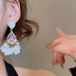 Detail of vintage court style earrings with purple teardrop crystal and resin flower petals
