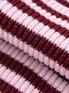 Gros plan sur la texture détaillée d'un tricot côtelé à rayures roses et rouge foncé