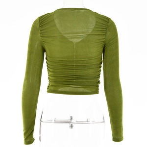 Détail du tissu en maille verte transparente avec texture plissée sur ce haut à manches