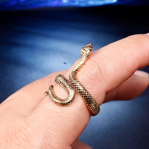 Close-up of vintage golden snake ring featuring intricate scale textures on finger