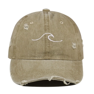 Detail of vintage washed khaki baseball cap with wave embroidery and distressed finish