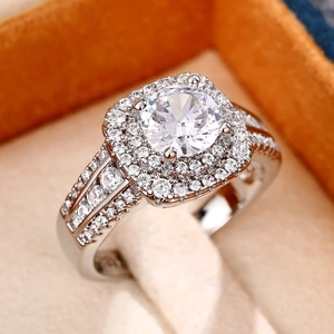 Luxe dubbele halo zirkonia ring met ronde hoofdsteen op een beige fluwelen doosje