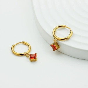 Golden titanium steel hoop earrings featuring square orange zircon pendants on white background