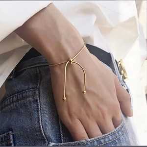 Detail of minimalist 18k gold plated snake chain bracelet featuring a unique knot design