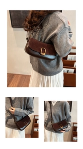 Detail of dark brown suede and leather shoulder bag with a gold metal oval lock