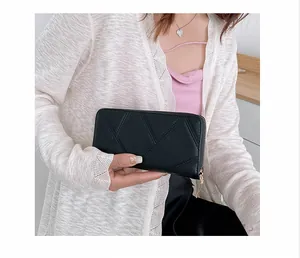 Close-up of black PU leather long wallet with geometric stitching and gold zipper