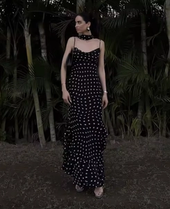 Polka dot ruffled maxi dress with spaghetti straps in a vintage outdoor resort setting