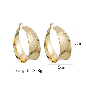 Detail view of 5cm gold C-shaped hoop earrings with brushed metal texture and 18.8g weight