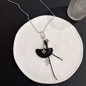 Dettaglio della collana a sfere argento con pendente a croce in pelle e stelle su ceramica