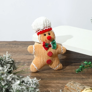 Detail of a handmade knitted gingerbread man ornament with a chef hat and bow tie