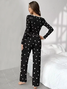 Detail of sweet black pajama set with white heart print and ruffled lettuce edges