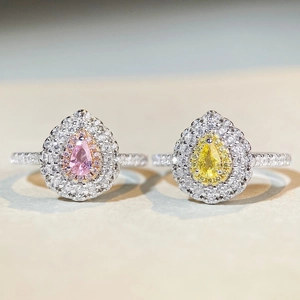 Detailed macro view of silver rings featuring pink and yellow pear-cut gemstone halos
