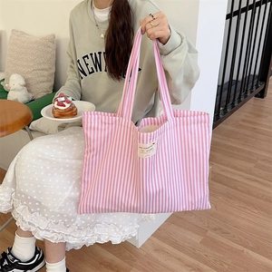 Pink and white striped canvas tote bag detail with decorative fabric label and thick texture