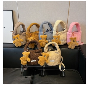 Colorful plush faux fur tote bags with cute bear charms and logo patch on display