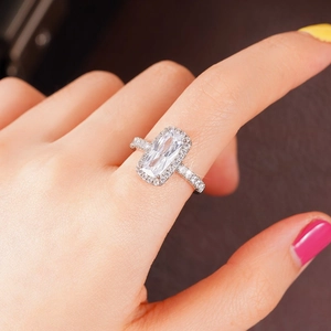 Detailopname van een zilveren ring met grote rechthoekige zirkoon en halo-zetting