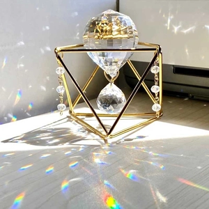 Close-up of geometric metal frame with K9 crystal prism creating rainbow reflections