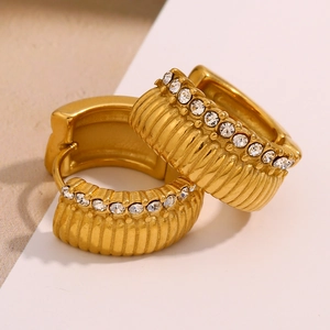 Macro detail of 18K gold plated hoop earrings with ribbed texture and white zircon stones