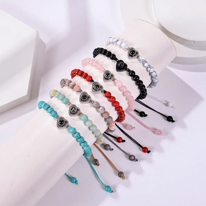 Multiple stone beaded bracelets with heart projection charms on a white display stand