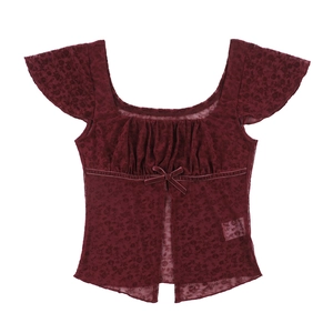 Detail of burgundy lace top featuring velvet bow tie and delicate mesh floral texture