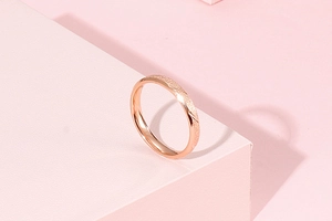 Detail of rose gold stainless steel ring with frosted sand finish and diagonal grooves