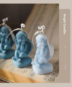 Detailed view of blue cherub angel scented candles on vintage music sheet paper