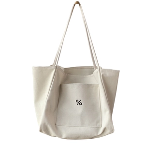 Minimalist ivory canvas tote bag with black percent logo shown in a vertical hanging view