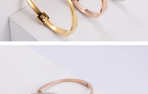 Macro detail of square zircon inlay on gold, rose gold and silver titanium steel bangles
