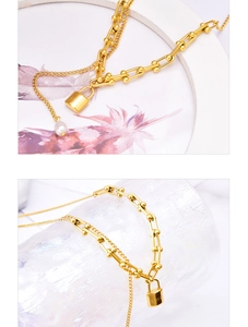 Macro detail of gold U-shaped link chain with pearl and LOVE padlock pendant necklace