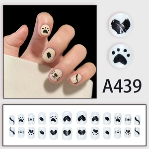 Cute cat paw print short press-on nails set in cream white with black doodle art patterns