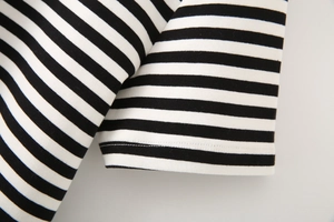 Close-up of the professional double-needle stitching on black and white striped knit fabric