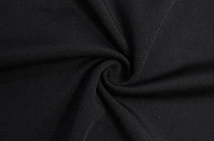 Détail du tissu en maille noire montrant la texture douce et les plis élégants