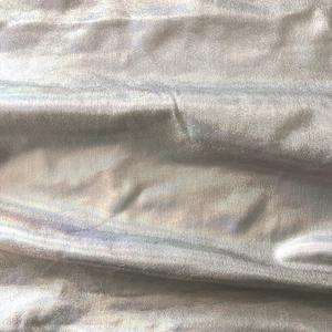 Vue macro du tissu argenté brillant avec un éclat métallique et des plis délicats